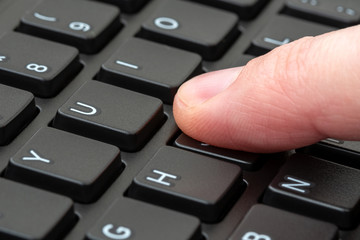 Hand typing on laptop keyboard