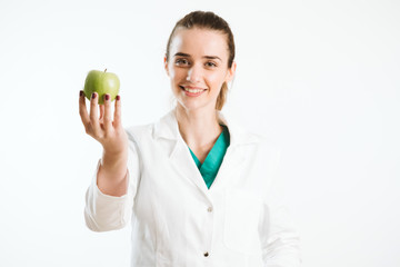 Wall Mural - Young nurse holding an apple, a healthy snack. 