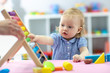 © Oksana Kuzmina - Little kid girl plays with abacus sitting at table
