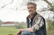 © goodluz - Attractive farmer leaning on fence looking at camera