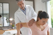 © goodluz - Physiotherapist helping patient with shoulder injury