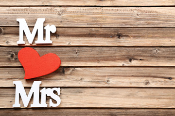 Wall Mural - White letters Mr and Mrs with red heart on brown wooden table