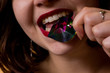 Young beautiful brunette girl with the gemstone in her mouth
