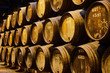 Old aged traditional wooden barrels with wine in a vault lined up in cool and dark cellar in Italy, Porto, Portugal, France