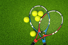 3d Rendering Of Two Tennis Rackets And Yellow Tennis Balls On Green Grass Background