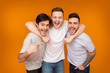 © Prostock-studio - Best friends. Men posing over orange background