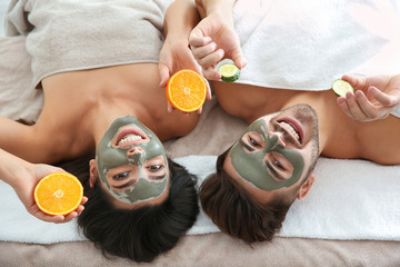 Wall Mural - Happy couple enjoying facial treatment procedure in spa salon, above view