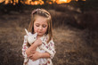 © Cavan Images - Portrait of young girl holding stuffed animal toy while looking down