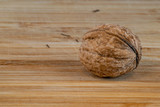 Fototapeta  - Single walnut on a wooden board