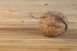 Fototapeta  - Single walnut on a wooden board
