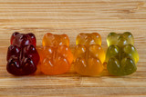 Fototapeta  - Colorful gummy bears on a wooden board