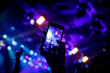 © 9parusnikov - Filming a concert on mobile phone camera, stage blue light