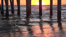 Waves Crashing Under A Pier During A Beautiful Sunset