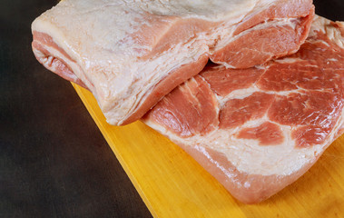 Raw pork leg on wooden cutting board ready for cooking