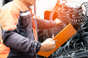 Wall Mural - Truck Driver is Checking the Semi Truck's Maintenance Checklist. Inspection Safety Before Driving. Freight Truck Transport.	