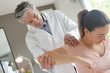 © goodluz - Physiotherapist helping patient with shoulder injury
