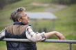 © goodluz - Relaxed farmer leaning on fence in field with closed eyes