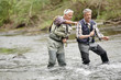 © goodluz - Fly fishing expert guiding novice in river