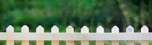 Beautiful Green Garden With White Fence And Blurred Background