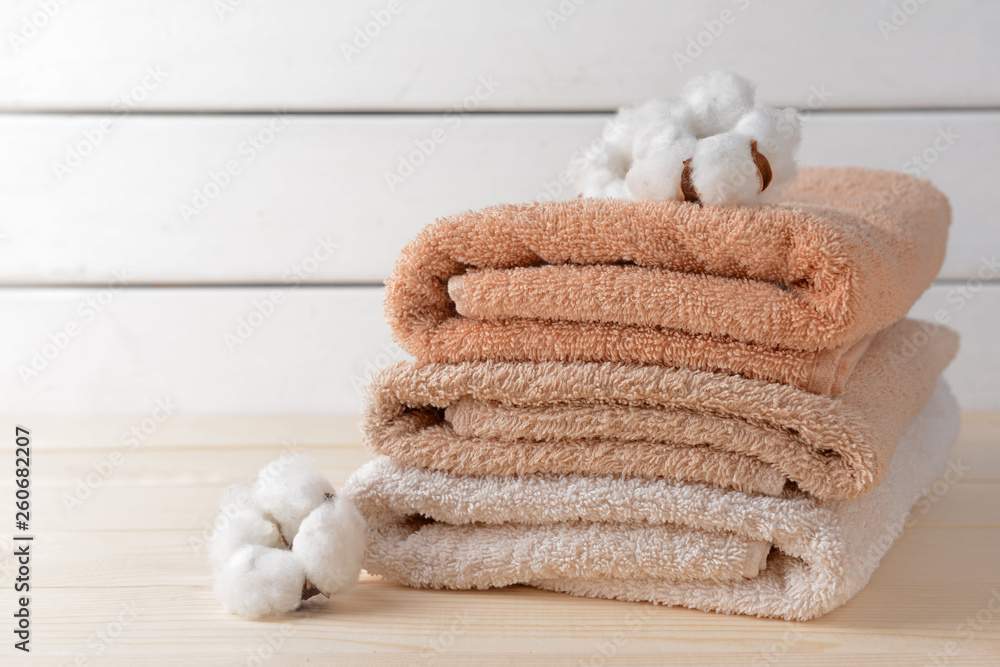 Cotton flowers with soft towels on wooden table
