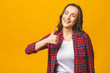 © denis_vermenko - Portrait of a pretty happy woman in casual posing isolated on a yellow background. Thumbs up.