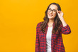 © denis_vermenko - Portrait of a pretty smiling woman in casual and glasses posing isolated on a yellow background.