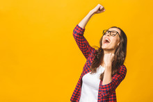 Winning Success Woman Happy Ecstatic Celebrating Being A Winner. Dynamic Energetic Image Of Multiracial Caucasian Asian Female Model Isolated On Yellow Background Waist Up.