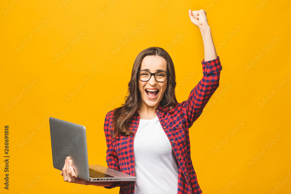 Portrait of an excited young beautiful girl holding laptop computer and ...