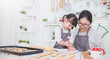 © paulaphoto - Portrait of little asian girl and mother baking cooking decorate cake and cookies in the kitchen. Happy asian family love together parenthood food nutrition mother’s day concept