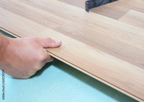 Contractor Installing Wooden Laminate Flooring With Insulation And