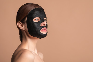 Wall Mural - Woman with black mask on the face thoughtfully looking away