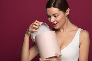 Wall Mural - Emotional woman feeling surprised while opening the present