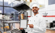 © Syda Productions - cooking, technology and people concept - happy male indian chef in toque with tablet computer over kebab shop kitchen background