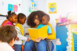 © Sergey Novikov - Group of little kids listen to teacher read story