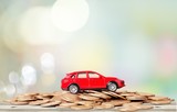 Fototapeta Mapy - Golden coins and toy car on  background