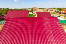 A House With A Red Roof Made Of Corrugated Metal Sheets. Roof From Corrugated Metal Profile. Metal Tiles.