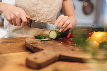 Wall Mural - Close up of a woman chopping vegetables