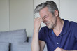 © goodluz - Mature man with bad headache at home