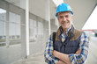 © goodluz - Construction worker looking at camera outside contemporary building