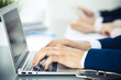 © rogerphoto - Group of business people working together in office. Man hands typing on laptop computer