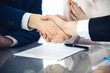 © rogerphoto - Business people shaking hands finishing up a meeting. Handshake at successful negotiation