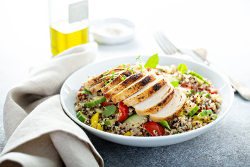 Wall Mural - Fresh quinoa tabbouleh salad with grilled chicken, tomatoes and cucumbers, healthy lunch bowl