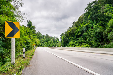 Beauty empty highway road with traffic signs and tree on cloudy sky background