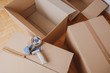 © Mego-studio - Tape dispenser sealing a shipping cardboard box