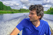 © Tatyana_Andreyeva - Handsome middle-aged man sitting at boat stern and floating along northern river on beautiful landscape background in summer day. Travel concept. Chernaya river, Karelia, Russia