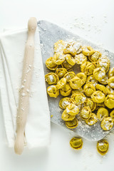 Wall Mural - raw ravioli tortellini on the table with flour and rolling pin. cooking healthy italian home cooking