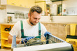 © Nomad_Soul - Worker in uniform repairs refrigerator compressor