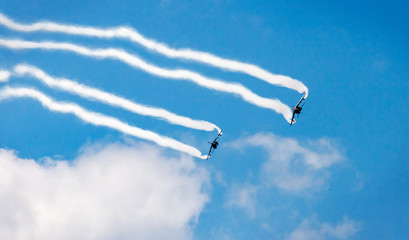 two airplanes with contrails in the sky