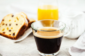 Wall Mural - Continental breakfast table with cup of hot black coffee, milk, cakes and orange juice