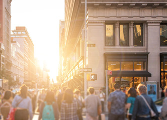 Wall Mural - Crowd of anonymous people walking down the busy sidewalk on 23rd Street in Manhattan, New York City with bright light of sunset